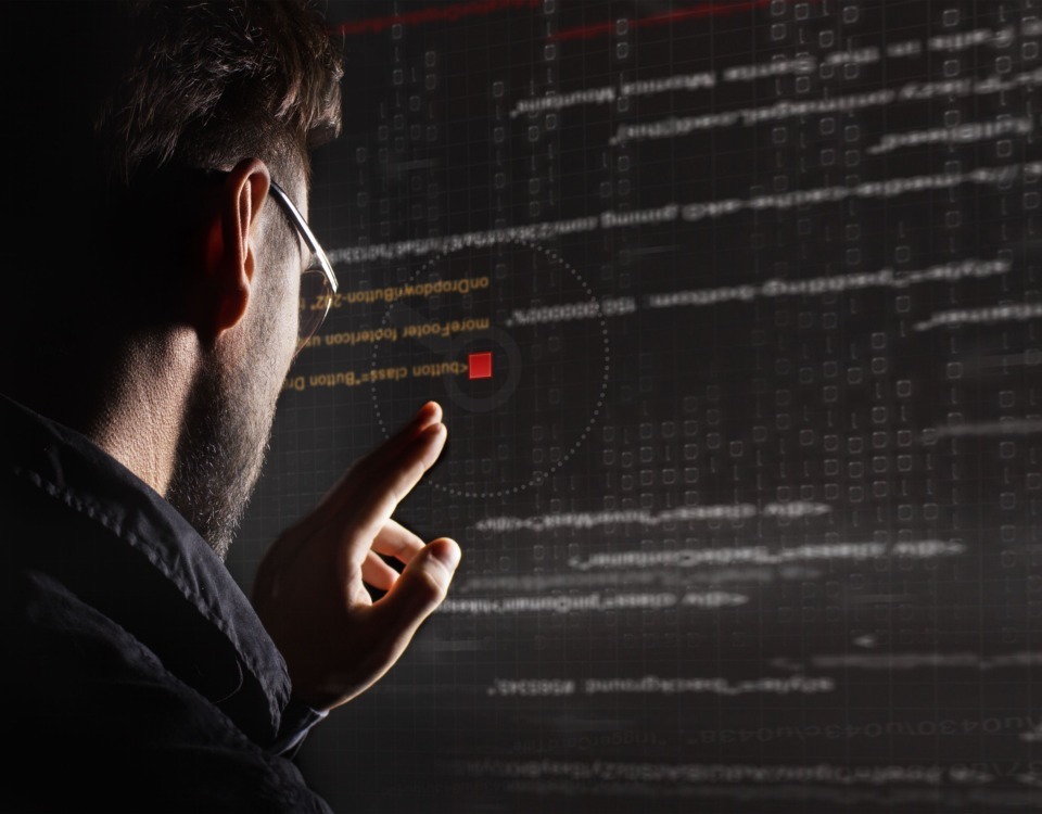 Hacker barbat care se uita pe un monitor