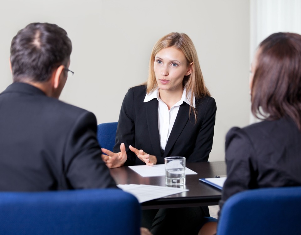 O femeie tânără vorbește cu doi recrutori despre calitățile sale.